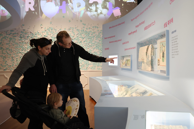 Pada tanggal 7 April 2026 sebuah keluarga wisatawan asing mengamati perkembangan gendongan bayi dari masa lalu hingga kini dalam pameran khusus Happy Birthday yang digelar di Museum Nasional Rakyat Korea di Jongno-gu, Seoul. Secara tradisional, Korea mengembangkan budaya eobuba, yakni menggendong bayi di punggung menggunakan podaegi&mdash;kain berlapis tebal dengan tali panjang. Berbeda dengan praktik di Barat yang umumnya menggendong bayi di bagian depan, metode pengasuhan tradisional Korea ini memiliki karakteristik unik yang memperkuat kedekatan antara ibu dan anak.