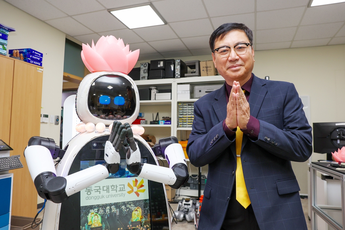 Lim Joong Yeon dari Departemen Teknik, Mesin, Robotika, dan Energi Universitas Dongguk berfoto bersama Hyean yang merupakan biksu robot AI pertama di Korea.  