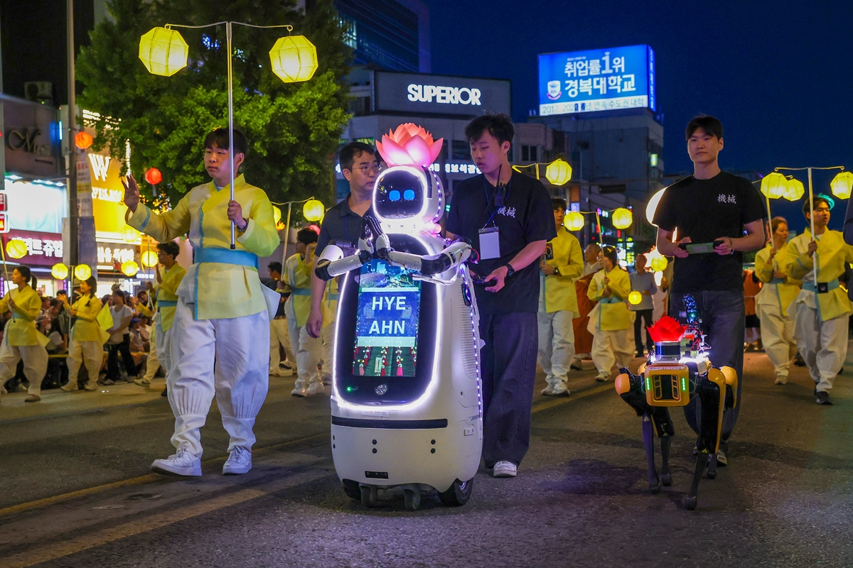 Biksu robot AI bernama Hyean dan dobot berkaki empat bernama Googi berada di barisan paling depan pawai lampion Universitas Dongguk dalam Festival Lentera Teratai (Yeondeunghoe) yang digelar pada tanggal 16 Mei 2026 untuk merayakan Hari Raya Waisak.  