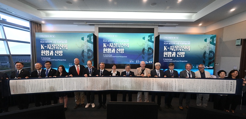 Para peserta simposium internasional terkait strategi konservasi KGA, berfoto bersama dengan Deklarasi Korea untuk KGA yang ditulis dalam gulungan sepanjang 9 meter pada tanggal 27 Mei 2026 di BEXCO, Busan. (Layanan Warisan Korea) 