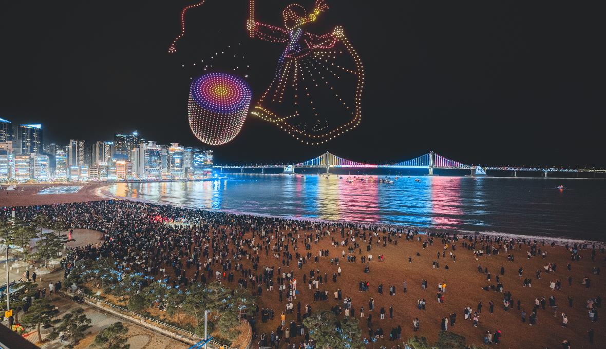 Gwangalli M Drone Light Show akan digelar di kawasan Pantai Gwangalli, Busan, pada pukul 22.00 tanggal 12&ndash;13 Juni 2026. Pertunjukan ini akan menghiasi langit malam Busan dengan cahaya warna-warni untuk memperingati BTS the City Arirang - Busan. (Visit Busan)