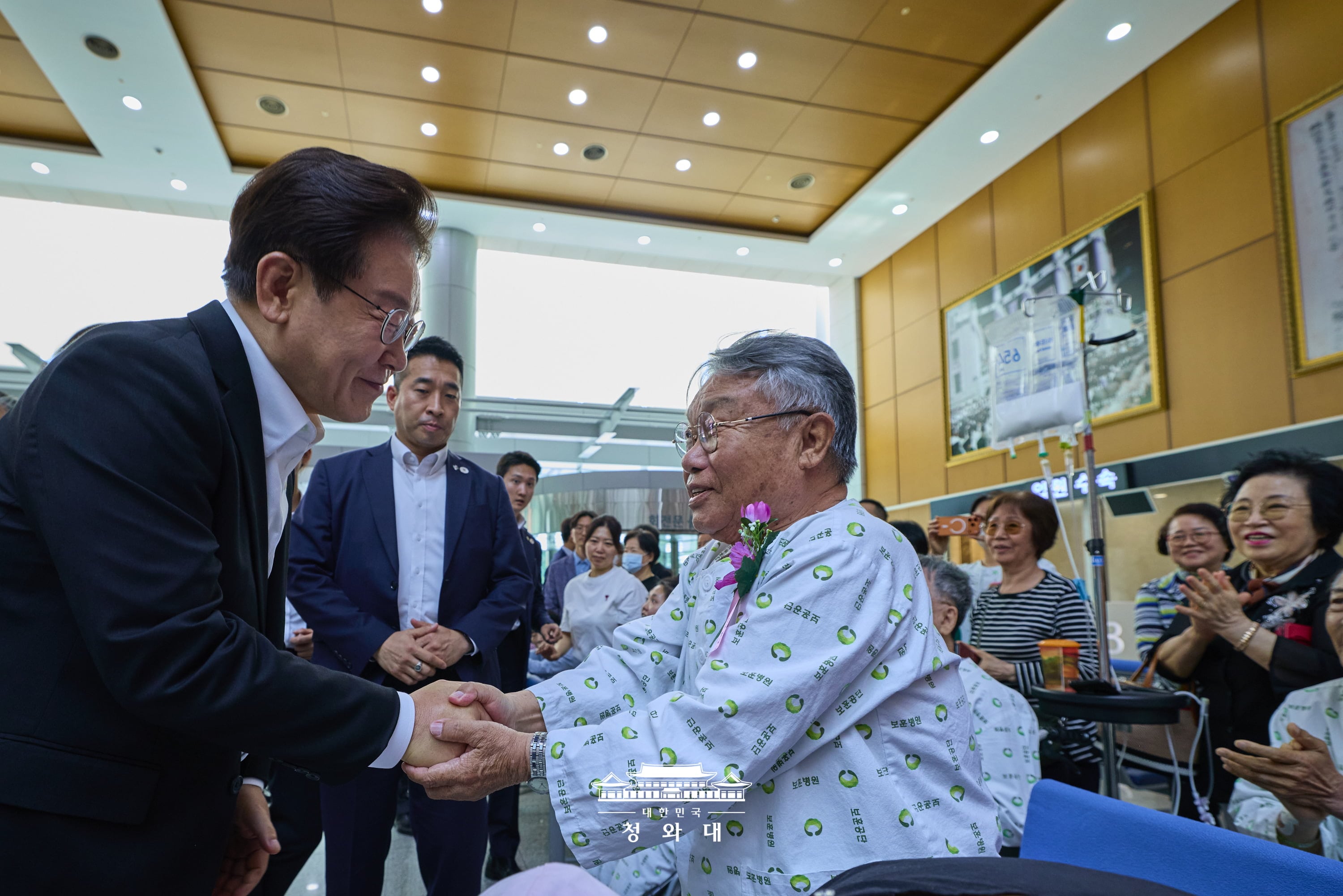 Presiden Lee Jae Myung (kiri) berdialog dengan seorang veteran saat mengunjungi Rumah Sakit Khusus Veteran di Seoul pada tanggal 6 Juni yang merupakan hari peringatan untuk para pahlawan dan veteran yang berjuang bagi Republik Korea. (Cheong Wa Dae)  