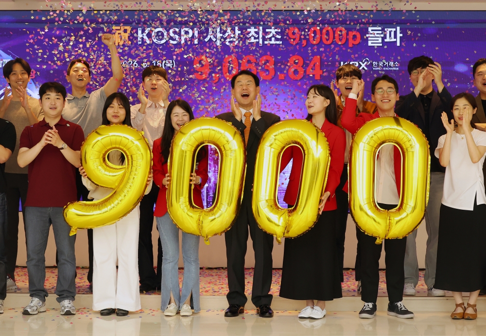 Indeks saham utama Korea, KOSPI, menembus level 9.000 untuk pertama kalinya. Para karyawan terlihat sedang melakukan selebrasi di ruang pamer promosi kantor pusat Korea Exchange (KRX) di Nam-gu, Busan, pada tanggal 18 Juni 2026. (Yonhap News)