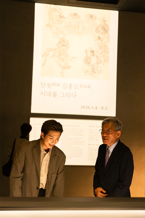 RM (kiri), anggota BTS yang ditunjuk sebagai duta promosi global Museum Nasional Korea, melihat pameran Kim Hongdo: Painting His Era bersama Direktur Museum Nasional Korea, You Hong June, di Galeri Lukisan dan Kaligrafi Museum Nasional Korea pada tanggal 19 Juni 2026.