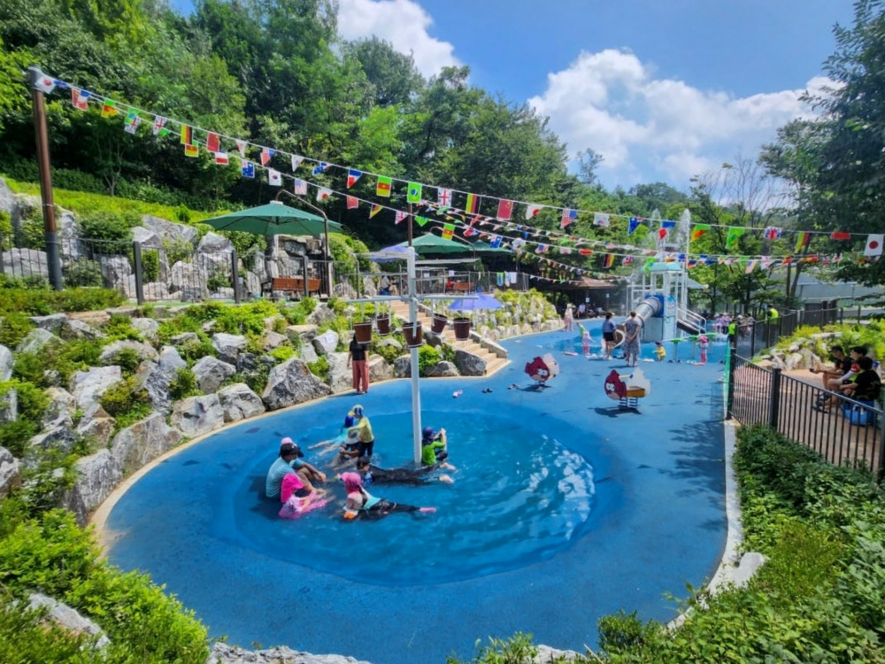 Anak-anak dan lansia dapat berkomunikasi dan bermain air di area bermain air Taman Hyeonchung yang terletak di Dongjak-gu, Seoul. 