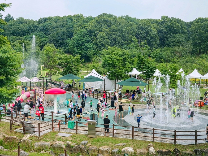 Para pegunjung terlihat menikmati area bermain air yang berada di dalam Area Perkemahan Jungnang, Jungnang-gu, Seoul.  