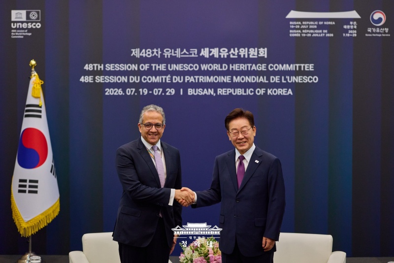 Presiden Lee Jae Myung (kanan) berjabat tangan dengan Direktur Jenderal UNESCO, Khaled El-Enany, sebelum acara pembukaan Sidang Komite Warisan Dunia UNESCO ke-48 yang digelar pada tanggal 19 Juli 2026 di Busan.  