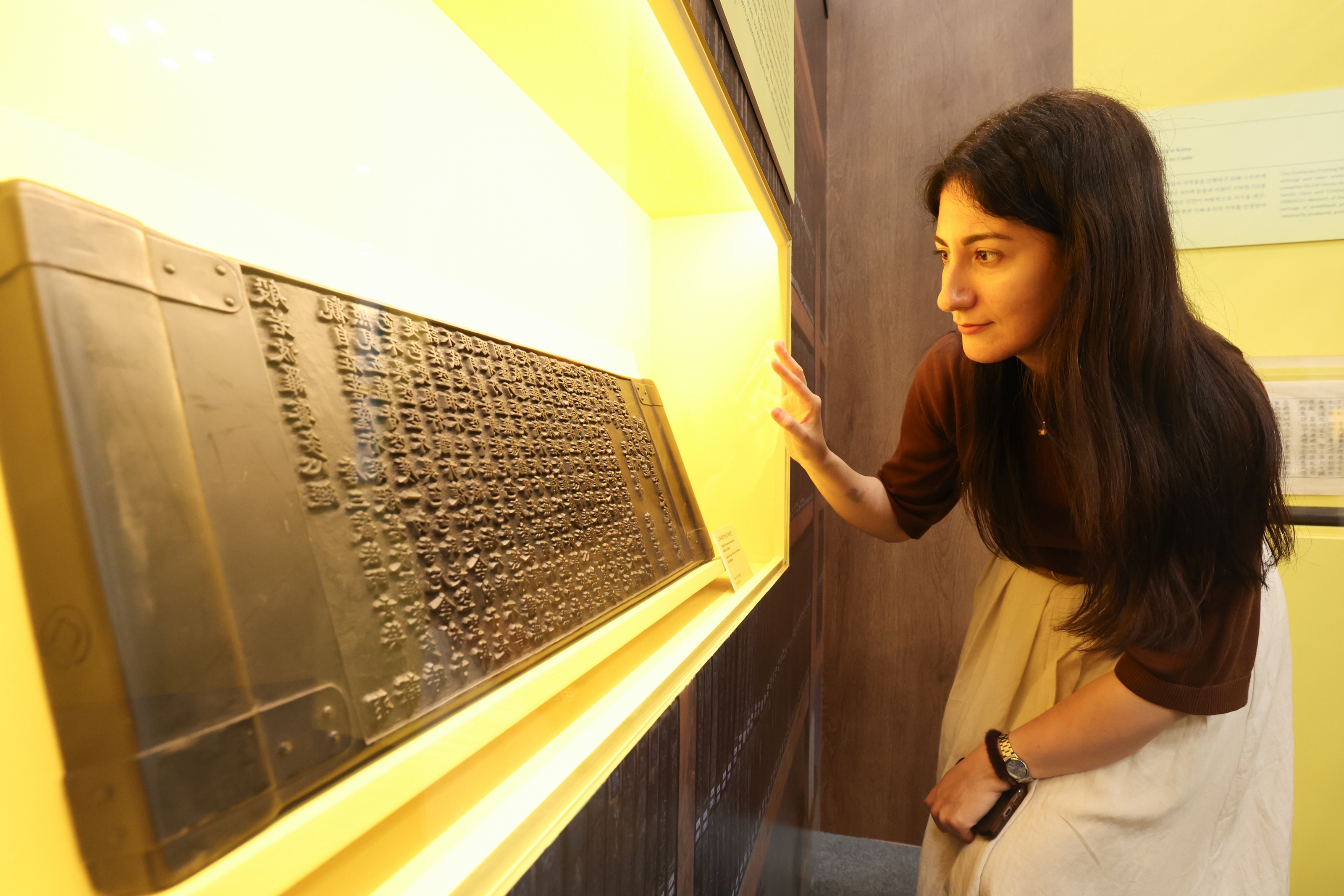 Seorang pengunjung asing memperhatikan pameran Tripitaka Koreana yang dipamerkan pada tanggal 23 Juli 2026 di K-Heritage House yang dibuka di BEXCO, Haeundae-gu, Busan.  