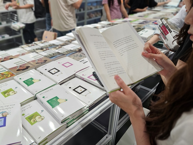 Seorang pengunjung melihat-lihat buku kumpulan puisi terbitan Minumsa hasil kolaborasi dengan karakter Korea di toko pop-up Minumsa X Daily Cutie: Dunia di Balik Kalimat pada tanggal 23 Agustus 2026 di I'Park Mall, Yongsan-gu, Seoul. (Lee Ji Yae)