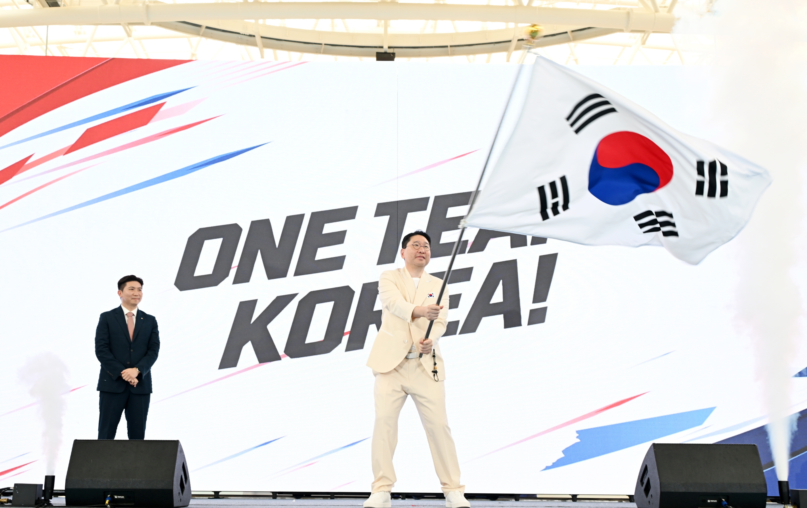 Ketua Kontingen Korea untuk Asian Games Aichi-Nagoya 2026, Lee Sang Hyun, mengibarkan bendera kontingen dalam upacara pelepasan pada tanggal 3 September 2026 di Pusat Pelatihan Atlet Nasional Jincheon, Provinsi Chungcheongbuk. (Komite Olahraga dan Olimpiade Korea)