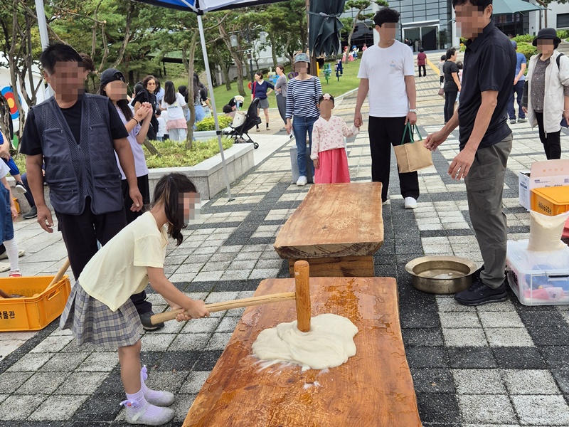 Seorang pengunjung mencoba menumbuk beras ketan kukus dengan palu kayu untuk membuat tok dalam acara Festival Permainan Tradisional Chuseok yang digelar pada tanggal 3-7 Oktober 2025 di Museum Nasional Jeonju, Wansan-gu, Kota Jeonju, Provinsi Jeollabuk. (Museum Nasional Jeonju)
