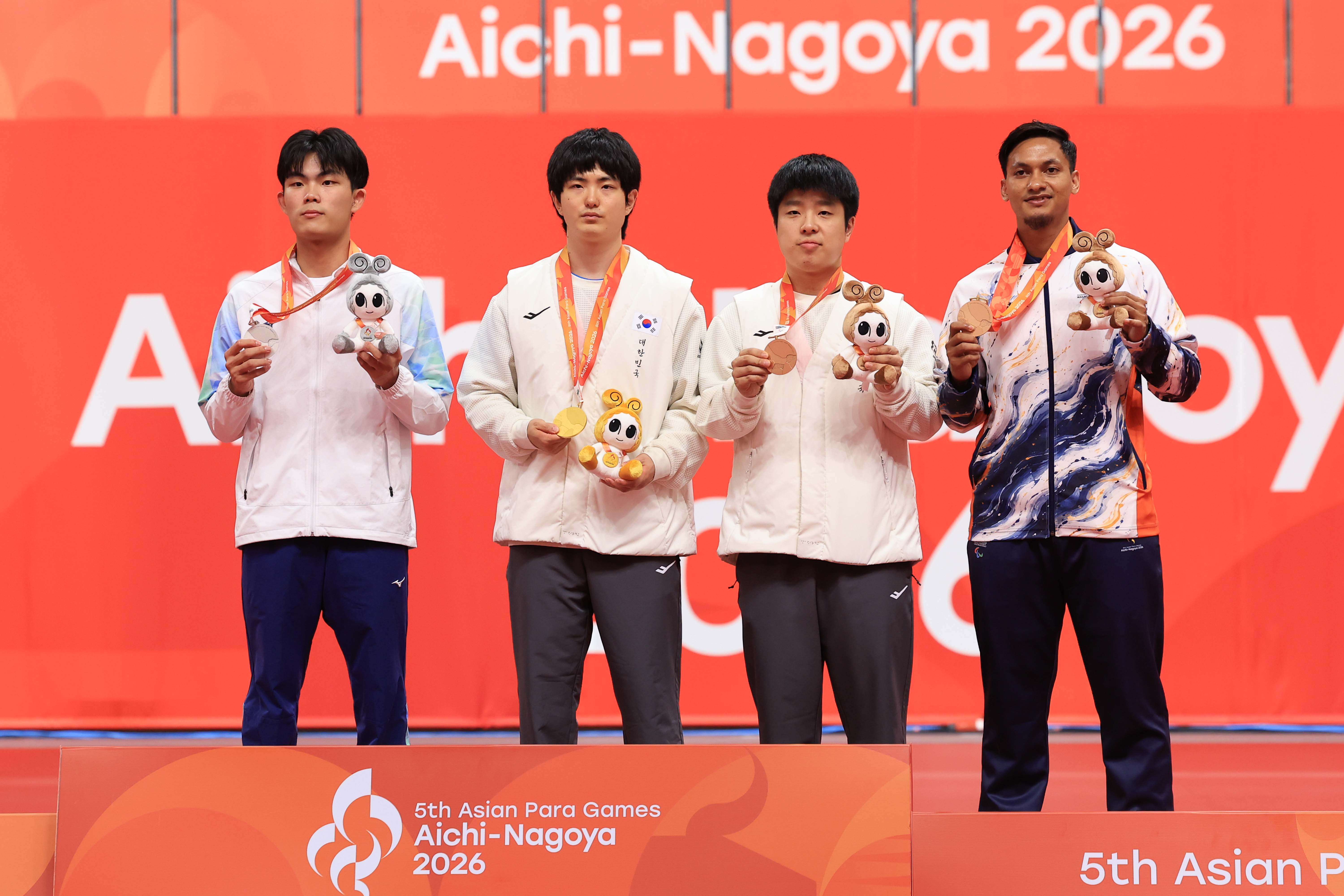 Peraih medali emas Kim Gitae (kedua dari kiri) dan peraih medali perunggu Kim Bogyeom (ketiga dari kiri) berfoto bersama dalam upacara penyerahan medali tenis meja tunggal putra kelas 11 Asian Para Games Aichi-Nagoya 2026 pada tanggal 20 Oktober 2026 di Sky Hall Toyota, Kota Toyota, Prefektur Aichi, Jepang.