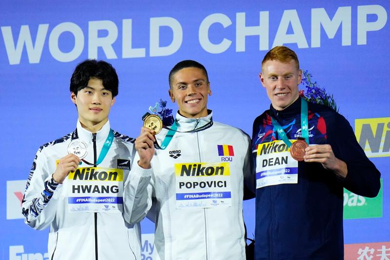 Hwang Sun-woo (kiri) pada 20 Juni berpose untuk foto pada upacara penghargaan setelah mengklaim medali perak dalam gaya bebas 200 m putra di Kejuaraan Dunia Renang FINA tahun ini, bersama dengan peraih medali emas David Popovici dari Rumania (tengah) dan peraih medali perunggu Tom Dean dari Inggris.(Yonhap News)