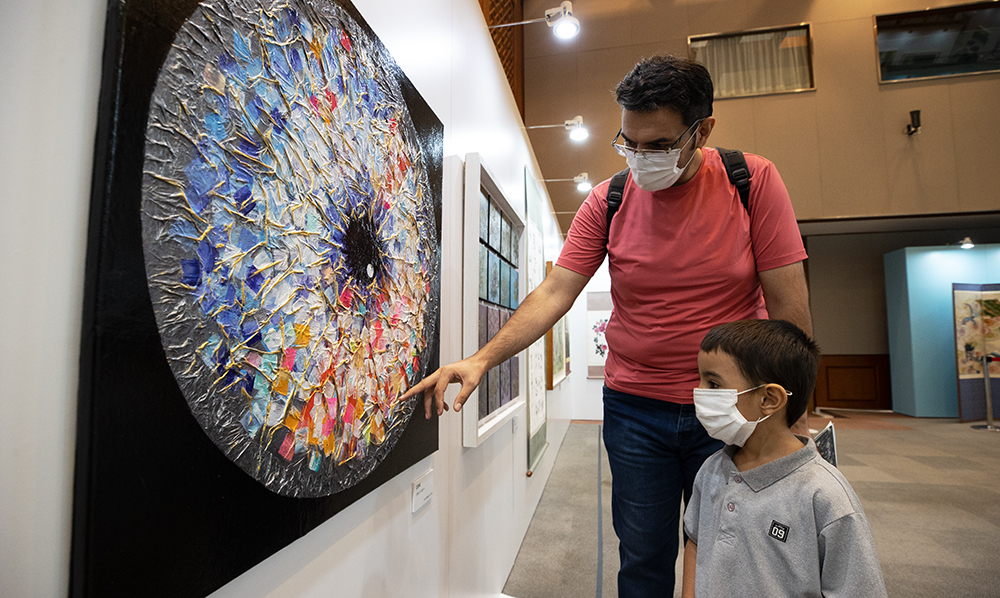 Seorang ayah dan anak asing sedang menonton pameran seniman penyandang disabilitas yang bertema 'Kembali ke Pelukan Rakyat, Kembali Berbaur dengan Rakyat' yang diadakan di Chunchugwan Cheong Wa Dae di Jongno-gu, Seoul pada tanggal 8 September. (Kim Sunjoo)