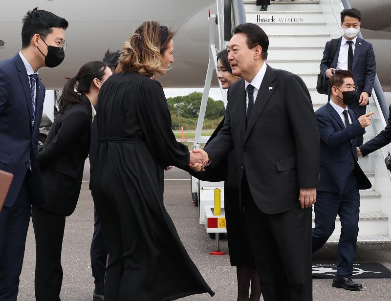 Presiden Yoon Suk Yeol dan istrinya Kim Keon-hee tiba di Bandara Stansted London, negara pertama yang mereka kunjungi pada tanggal 18 September (waktu setempat), dan berjabat tangan dengan orang-orang yang menyambut mereka. (Yonhap News)