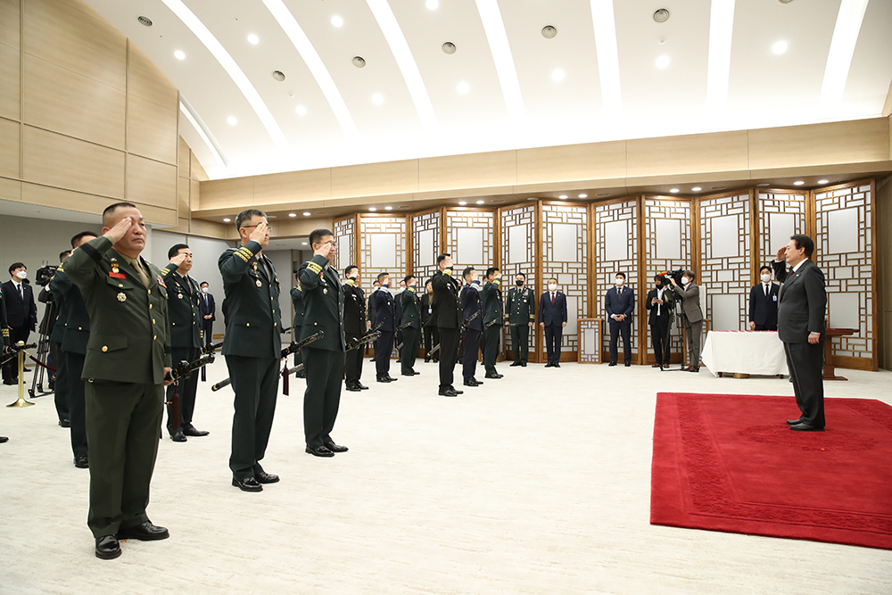 Presiden Yoon Suk Yeol pada pagi hari tanggal 7 Desember memberi hormat kepada para jenderal yang baru dipromosikan pada upacara pengangkatan yang diadakan di Kantor Kepresidenan di Yongsan-gu, Seoul. Presiden Yoon memberi mereka pita bersenar untuk ditaruh di pedang samjeonggeom. Biasanya itu diberikan kepada personel militer yang naik pangkat dari kolonel menjadi brigadir jenderal. Bagi mereka yang naik pangkat menjadi letnan jenderal atau lebih tinggi, presiden mengikatkan semacam pita merah muda bertuliskan pangkat, nama dan tanggal pembawanya di sekitar gagang pedang yang diterima ketika seseorang dipromosikan menjadi brigadir jenderal. Samjeong (tiga roh) mengacu pada pertahanan nasional, reunifikasi, dan kemakmuran yang dicapai melalui solidaritas antara Angkatan Darat, Angkatan Laut, dan Angkatan Udara Republik Korea. Delapan belas letnan jenderal termasuk komandan marinir masing-masing menerima suchi untuk pedang mereka pada upacara ini. (Yonhap News)