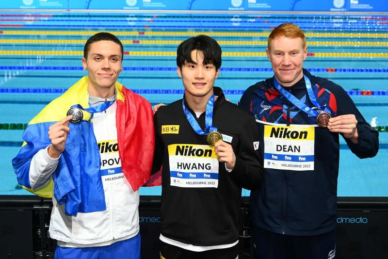 Hwang Sunwoo (tengah) berpose di upacara penghargaan setelah memenangkan medali emas gaya bebas 200 m putra di Kejuaraan Renang Dunia Short Course FINA 2022 dengan peraih medali perak David Popovici (Romania, kiri) dan peraih medali perunggu Tom Dean (Inggris) yang diadakan di Melbourne, Australia pada tanggal 18 Desember.