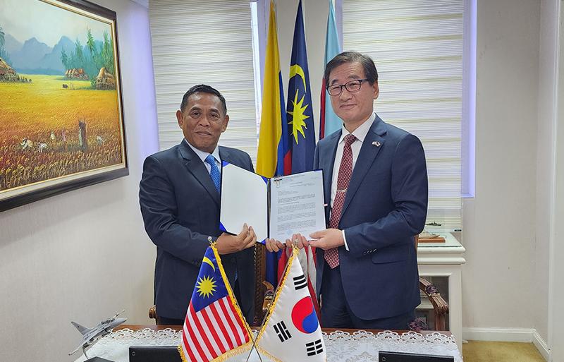 CEO KAI, Kang Gu-young (kanan) dan Sekretaris Jenderal Kementerian Pertahanan Malaysia, Datuk Muez bin Abd Aziz (kiri) menandatangani kontrak ekspor 18 unit jet tempur FA-50 lalu berfoto bersama pada tanggal 24 Februari. (KAI) 