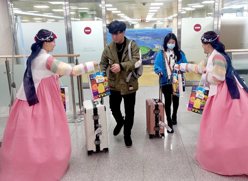  Para turis yang tiba di Jeju dari Shanghai sedang menerima suvenir dari Pemerintah Provinsi Jeju saat tiba di Bandara Jeju pada tanggal 26 Maret. 