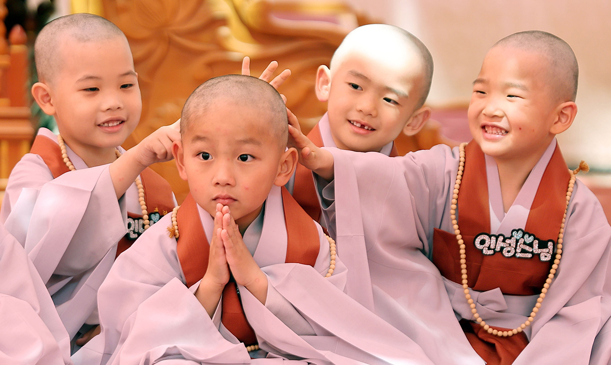 Pada tanggal 9 Mei, para biksu muda saling menyentuh kepala satu sama lain setelah menggunduli rambutnya di upacara pembelajaran prinsip Buddha di Sekolah Tunas Pohon Bodhi (terjemahan tidak resmi). Upacara tersebut diadakan di halaman depan Aula Daeungjeon (Dharma Utama) di Kuil Jogyesa di Distrik Jongno-gu Seoul. Sembilan biksu muda berusia 6-7 tahun akan membuat persembahan pada Buddha dan belajar tata krama Buddha bersama para biksu di Kuil Jogyesa tanpa didampingi oleh orang tua mereka. Mereka masing-masing menerima nama ala Buddha dan berpartisipasi dalam berbagai program hingga 29 Mei tanpa kembali ke rumah selama 21 hari. Jogyesa melaksanakan program penggundulan rambut biksu muda dan pengajaran prinsip Buddha untuk pertama kalinya dalam empat tahun sejak tahun 2019, setahun sebelum Pandemi COVID-19. (Yonhap News) 