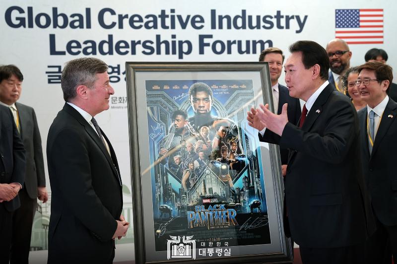 Presiden Yoon Suk Yeol (kanan) berbincang bersama Charles Rivkin (kiri), Pimpinan MPA (Motion Picture Association) pada Forum Pemimpin Industri Kreatif Global yang digelar pada tanggal 27 April (waktu setempat) di kantor global MPA yang terletak di Washington DC. Presiden Yoon berkata, Tidak ada batas negara dalam industri budaya. Kita harus menghapus hal-hal yang tidak cocok dengan standar dunia. Pada hari itu, Presiden Yoon menerima hadiah dari MPA berupa poster film Black Panther yang ditandatangani oleh sutradaranya. Presiden Yoon mengungkapkan, Pemerintah Korea akan memberikan bantuan aktif untuk membuat konten bersama antara Korea dan AS, seperti Black Panther yang sebagian adegannya diambil di Kota Busan. 