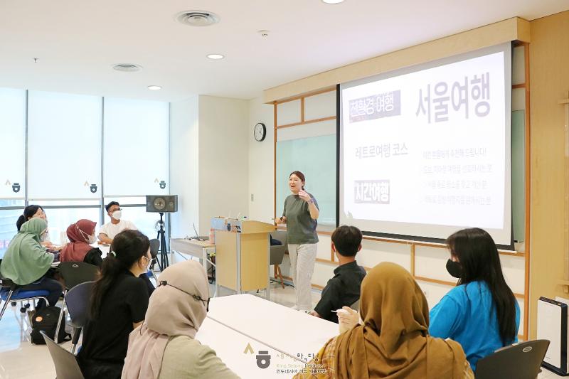 Seorang pengajar KSIC (King Sejong Institute Center) Indonesia sedang menjelaskan mengenai wisata Kota Seoul kepada para siswa pada tanggal 30 Mei. (Facebook resmi KSIC Indonesia) 