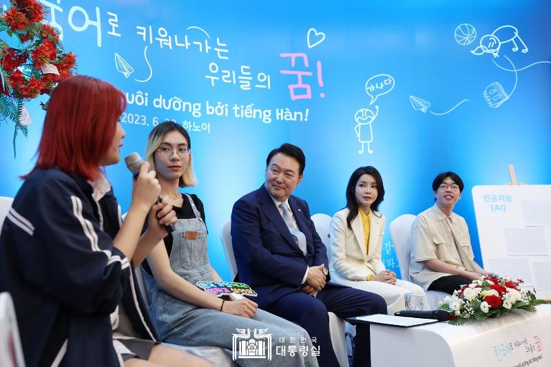 Presiden Yoon Suk Yeol (ketiga dari kanan) dan Ibu Negara Kim Keon Hee (kedua dari kanan) berbagi cerita dengan beberapa pemelajar bahasa Korea di Vietnam pada tanggal 22 Juni (waktu setempat) di Vietnam National University, Hanoi. 