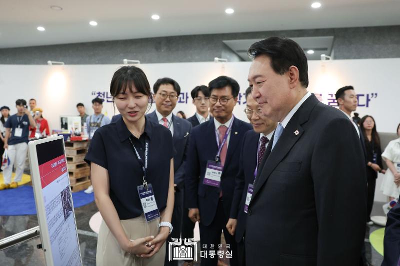 Presiden Yoon Suk Yeol sedang mendengarkan penjelasan dari seorang ilmuwan muda di stan informasi per negara dalam acara The 1st World Congress of Korean Scientists & Engineers yang digelar pada tanggal 5 Juli di The Korea Science and Technology Center, Gangnam-gu, Seoul.