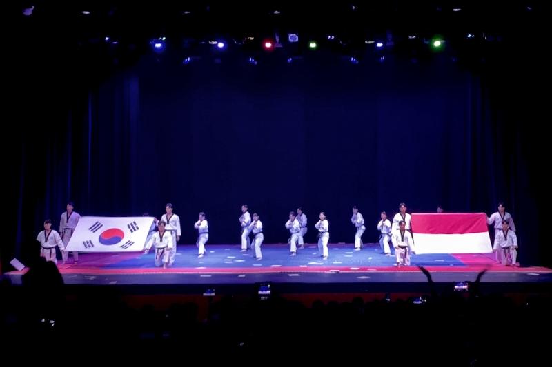 Tim Demonstrasi Taekwondo KUKKIWON membentangkan bendera Korea dan Indonesia di akhir acara.