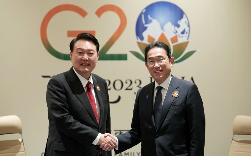 Presiden Yoon Suk Yeol (kiri) dan Perdana Menteri Jepang, Fumio Kishida, berjabat tangan pada KTT Korea-Jepang yang digelar pada tanggal 10 September (waktu setempat) dalam perhelatan KTT G20 di New Delhi, India. (Kim Yong Wii, Kantor Kepresidenan Republik Korea) 