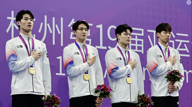 Dari kiri ke kanan: Hwang Sun-woo, Kim Woo-min, Lee Ho-joon, dan Yang Jae-hoon memberi hormat kepada bendera nasional setelah menerima medali emas pada pengalungan medali setelah final nomor estafet 800 m putra Asian Games Hangzhou yang diadakan pada tanggal 25 September (waktu setempat) di Hangzhou Olympic Sports Centre Aquatic Sports Arena.