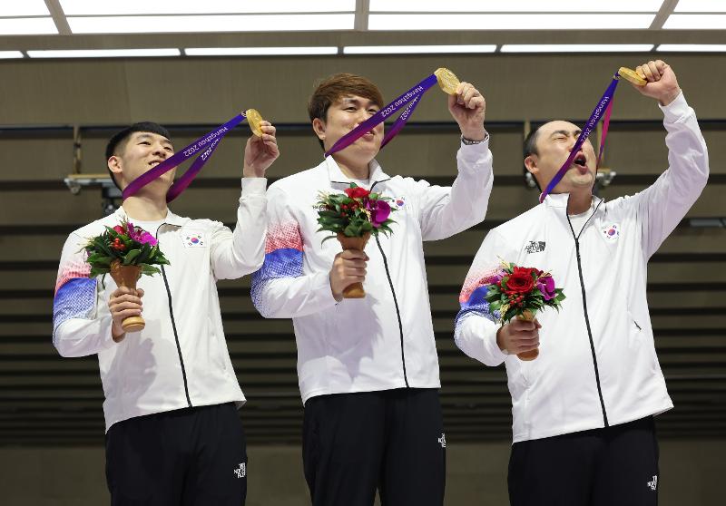 wak Yongbin (kiri), Jeong Youjin (tengah), dan Ha Kwangchul berfoto setelah menerima medali emas pada pertandingan cabor menembak running target 10 m campur beregu yang digelar pada tanggal 26 September (waktu setempat) di Fuyang Yinhu Sports Centre, Hangzhou, Tiongkok.