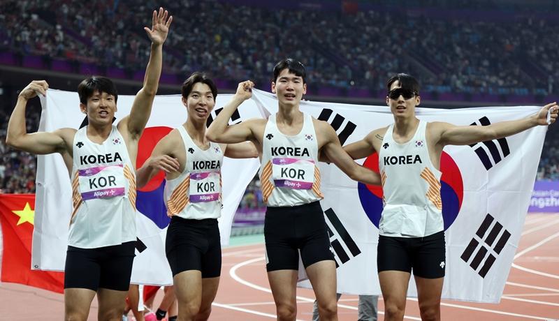 Timnas Korea untuk cabor lari estafet 4x100 meter putra memegang bendera nasional Korea setelah berhasil meraih medali perunggu pada babak final yang digelar tanggal 3 Oktober di Hangzhou Olympic Sports Centre Stadium. Dari kiri ke kanan: Kim Kukyoung, Lee Jeongtae, Lee Jaeseong, dan Ko Seunghwan.