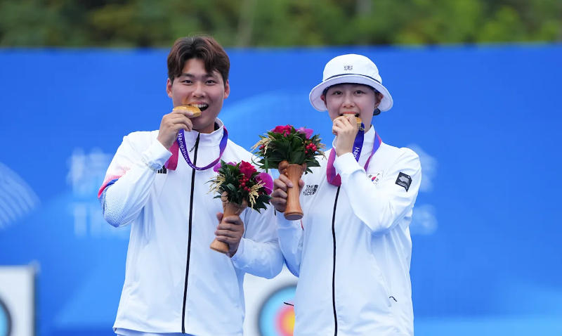 Lee Wooseok dan Lim Sihyeon tersenyum dengan menggantungkan medali emas di leher mereka setelah memenangkan pertandingan final panahan rberegu campuran di Asian Games Hangzhou yang diadakan pada tanggal 4 Oktober (waktu setempat) di Fuyang Yinhu Sports Centre, Hangzhou, Tiongkok.