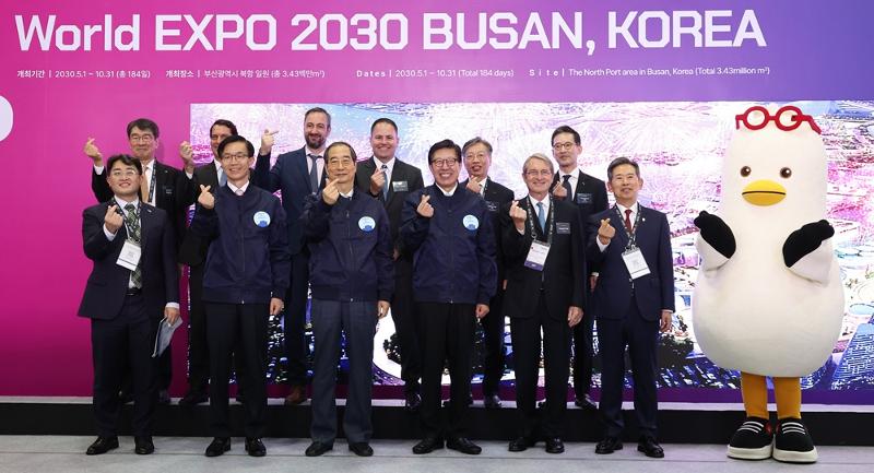 Perdana Menteri Han Duck-soo (ketiga dari kiri di baris pertama) pada 7 November mengambil foto sambil mengenakan pakaian dengan harapan untuk Busan menjadi tuan rumah 2030 World Expo di stan promosi terkait. PM Han mengunjungi ruang pameran Invest Korea Summit tahun ini di BEXCO, Haeundae-gu, Kota Busan. (Yonhap News)