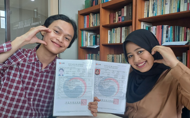 Potret penulis (kiri) dan Fakhira (kanan) memegang sertifikat TOPIK.