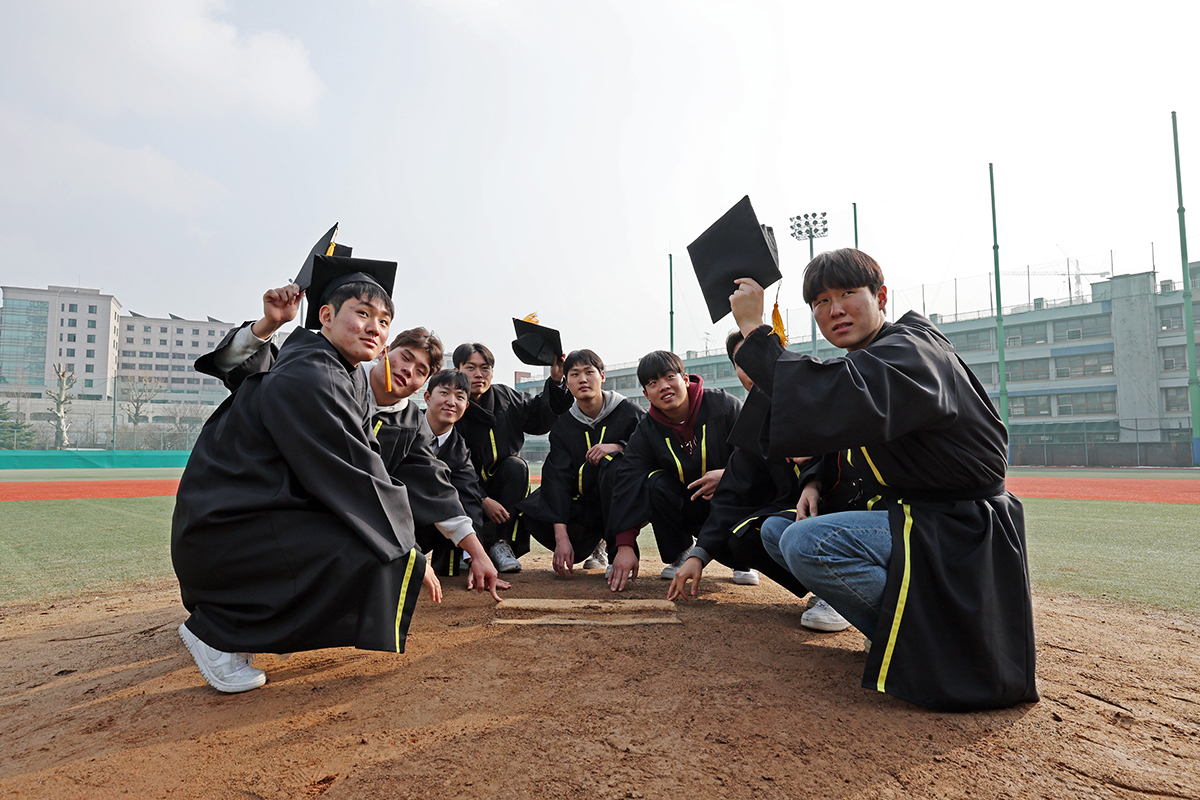 Para lulusan baru siswa SMA Duksoo jurusan bisbol berfoto bersama di lapangan bisbol pada tanggal 5 Januari. (Yonhap News)