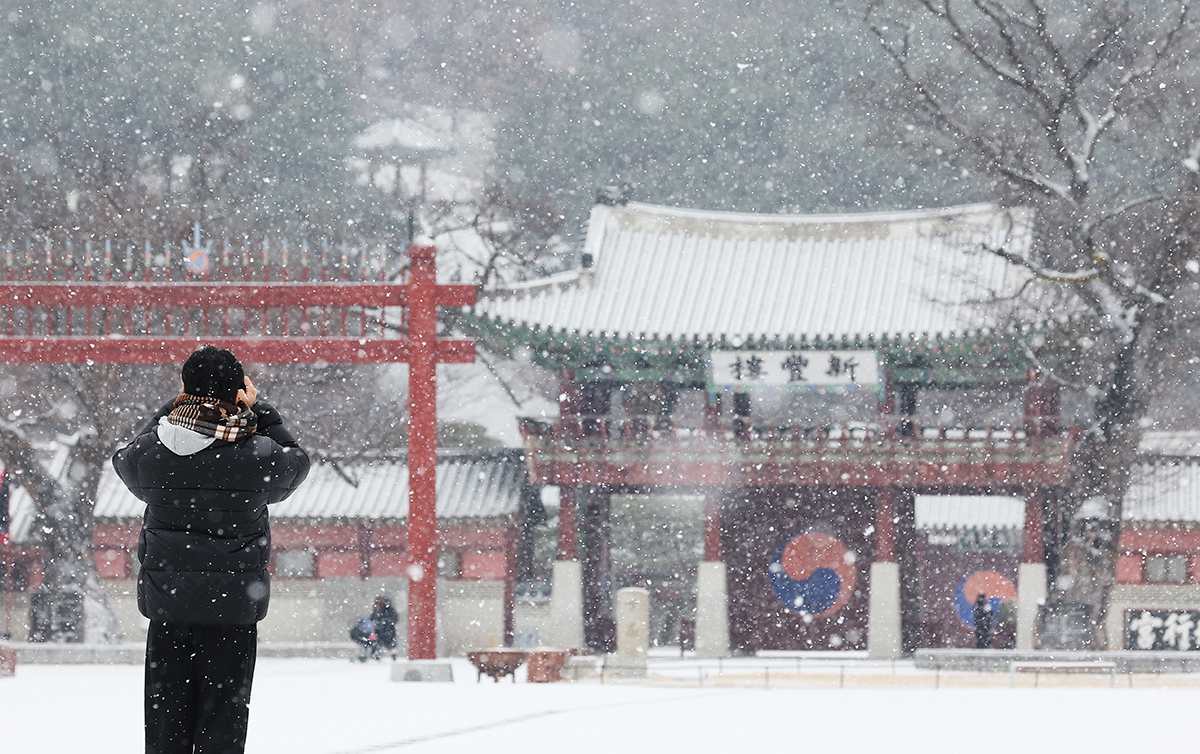 Seorang wisatawan terlihat sedang menikmati pemandangan bersalju pada pagi hari tanggal 9 Januari di Istana Hwaseong Haenggung, Paldal-gu, Kota Suwon, Provinsi Gyeonggi. (Yonhap News)