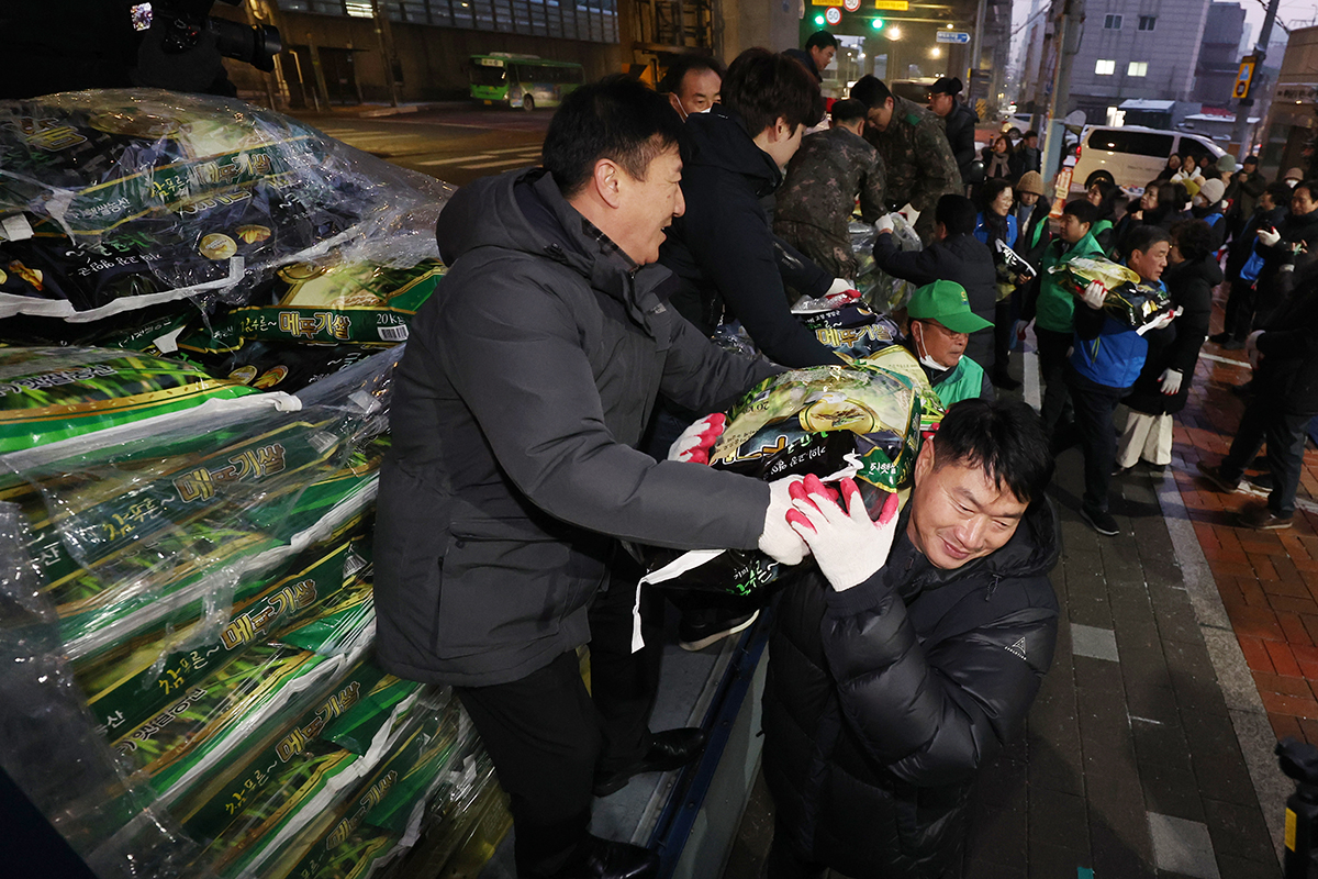 Beberapa orang warga dan pejabat kecamatan setempat terlihat sedang memindahkan beras yang dikirim oleh seorang donatur anonim pada tanggal 10 Januari di depan Kantor Kelurahan Wolgok 2(i)-dong, Seongbuk-gu, Seoul. Donatur anonim yang disebut sebagai 'malaikat tak berwajah' oleh masyarakat setempat ini telah mengirimkan 300 karung beras berisi 20 kg setiap tahun sejak tahun 2011 untuk dibagikan kepada masyarakat yang kurang mampu. (Yonhap News)
