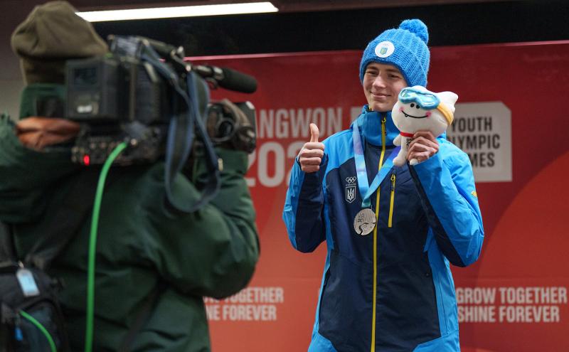 Yaroslav Lavreniuk berfoto dengan maskot Gangwon 2024 bernama Moongcho setelah berhasil meraih medali perak pada cabang olahraga skeleton perorangan pria Gangwon 2024 yang digelar pada tanggal 23 Januari di Alpensia Sliding Centre, Pyeongchang-gun, Provinsi Gangwon. (Layanan Informasi Olimpiade (OIS)/IOC) 