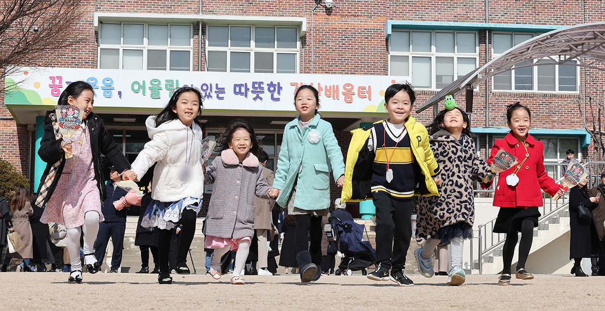 Para siswa baru terlihat sedang bergandengan tangan menyambut orang tua mereka pada hari pertama tahun ajaran baru 2024 di SD Galsan, Yangcheon-gu, Seoul. Tanggal 4 Maret merupakan hari pertama tahun ajaran 2024 di Korea. (Yonhap News)