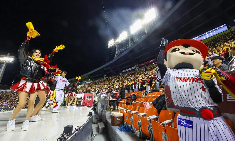 Foto di atas menunjukkan tim pandu sorak, maskot, dan para penggemar tim bisbol LG yang sedang menyoraki tim LG Twins yang sedang melawan tim kt wiz pada Post Season Korean Series babak pertama yang digelar tanggal 7 November 2023 lalu di Stadion Bisbol Jamsil, Songpa-gu, Seoul. (Yonhap News)
