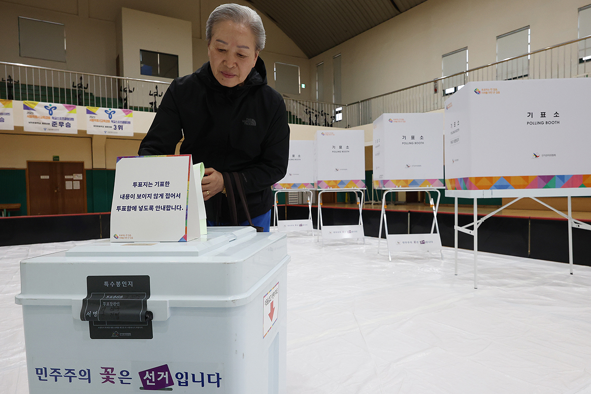 Pada pagi hari tanggal 10 April, seorang pemilih terlihat sedang memasukkan surat suaranya ke dalam kotak suara di TPS ke-3 Huam-dong, Sekolah Dasar Samgwang, Yongsan-gu, Seoul. Hari Pemilihan Umum Legislatif Korea yang ke-22 jatuh pada tanggal 10 April. (Yonhap News)