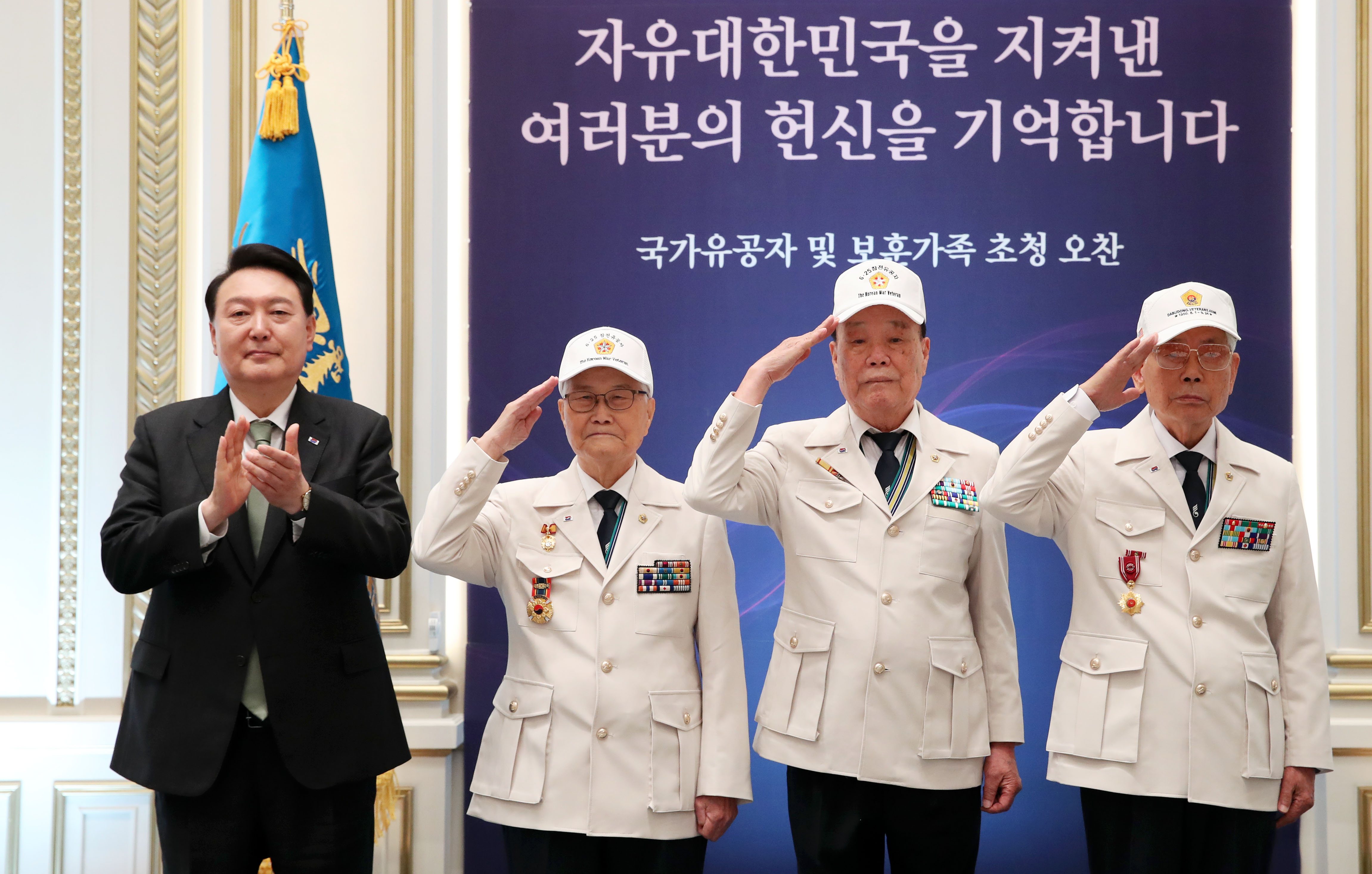 Presiden Yoon Suk Yeol (paling kiri) berfoto bersama dengan Son Hee Won (Kepala Asosiasi Veteran Perang Korea, kedua dari kiri), Kim Chang Seok, dan Lee Ha Yeong pada jamuan makan siang bersama keluarga veteran Perang Korea (1950-1953) dan pihak-pihak yang berjasa bagi negara pada tanggal 14 Juni 2023 di Yeongbingwan, Cheong Wa Dae, Seoul. Foto ini diambil setelah Presiden Yoon memakaikan langsung seragam pahlawan kepada para veteran Perang Korea. Pemerintah membentuk Kementerian Urusan Patriot dan Veteran per tanggal 5 Juni 2023 dan meningkatkan dana kompensasi bagi veteran perang sebesar 5,5%. 