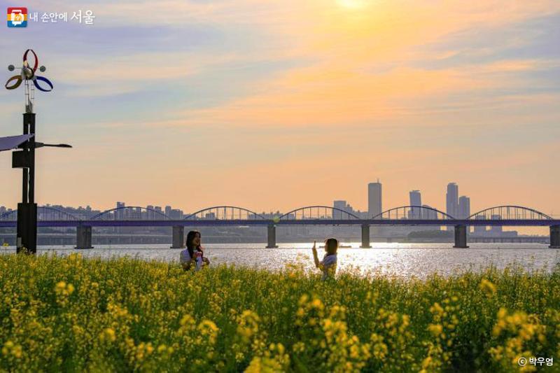 Warga terlihat sedang berfoto dengan latar belakang matahari terbenam dan Sungai Hangang pada tanggal 8 Maret di Pulau Seoraeseom, Seocho-gu, Kota Seoul. (Jurnalis Warga Kota Seoul, Park Woo Young) 