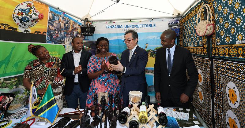 Menteri Luar Negeri, Cho Tae-yul pada tanggal 10 Mei (kedua dari kanan) mendengarkan penjelasan tentang kerajinan tangan tradisional saat berkunjung ke stan Kedutaan Besar Tanzania di Korea pada Festival Budaya Afrika tahun 2024 yang berlangsung di Alun-alun Gwanghwamun, Kota Seoul.