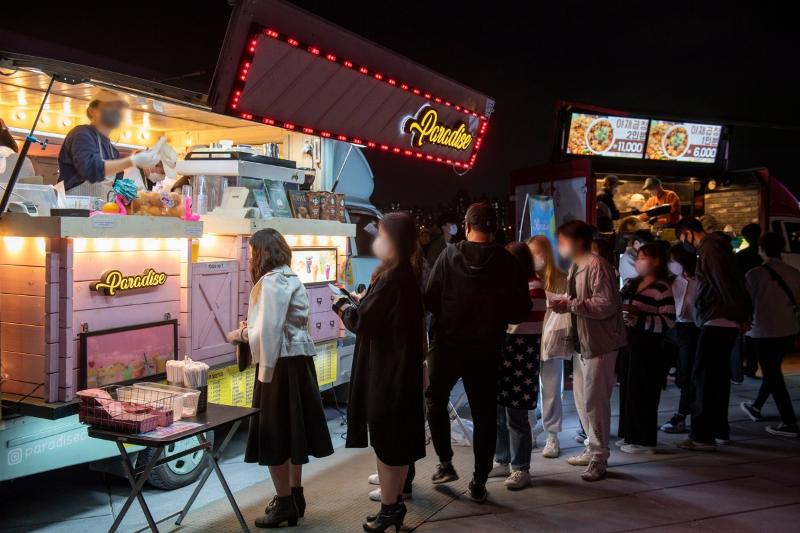 Foto di atas menunjukkan warga yang sedang mengantre untuk membeli makanan pada Hangang Moonlight Market yang digelar pada bulan Juni 2023 di Taman Banpo Hangang, Seoul. (Pemerintah Kota Seoul)  