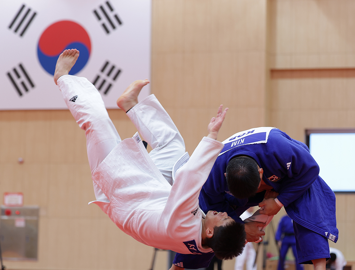 Kim Minjong (seragam berwarna biru) memperlihatkan teknik bantingan judo dalam acara Media Day timnas judo Korea untuk Olimpiade Paris 2024 yang digelar pada tanggal 13 Juni 2024 di Pusat Pelatihan Atlet Nasional Jincheon, Provinsi Chungcheongbuk. Kim adalah atlet Korea yang akan mewakili Korea pada cabang olahraga judo di kelas 100 kg putra. (Yonhap News)