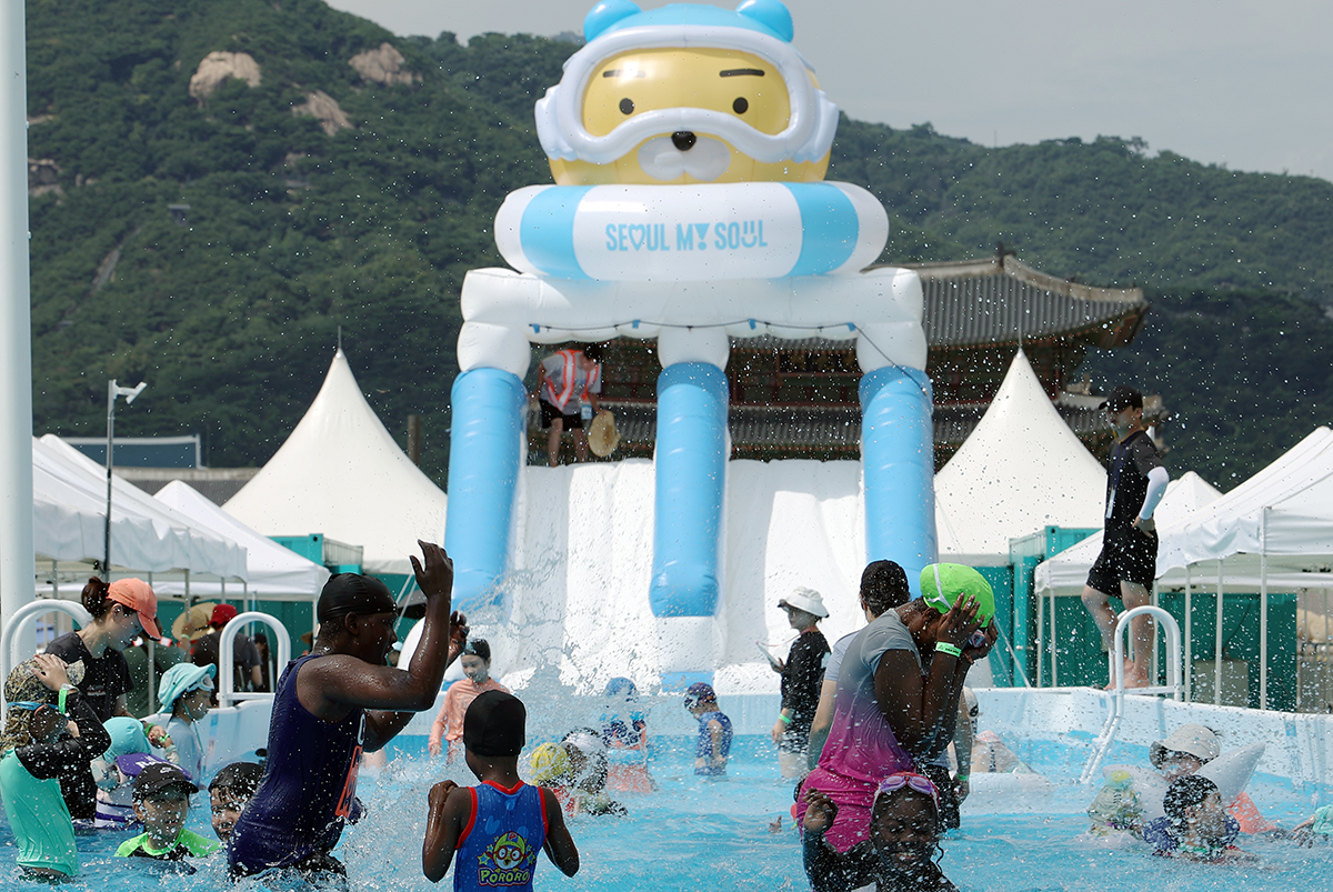 Para wisatawan asing terlihat sedang bermain air di tengah acara 2024 Seoul Summer Beach pada tanggal 25 Juli 2024 di Alun-alun Gwanghwamun, Jongno-gu, Seoul. Seoul Summer Beach tahun ini akan berlangsung hingga tanggal 11 Agustus 2024. (Lee Jun Young)