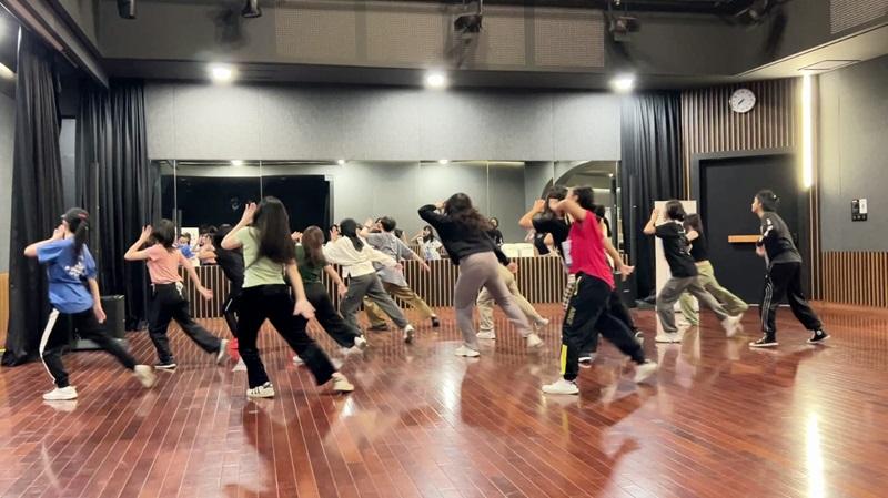 Suasana latihan kelas tari K-pop tingkat menengah. 